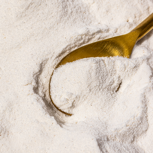 SuperGut supplement powder in measuring spoon showing clean, white powder texture